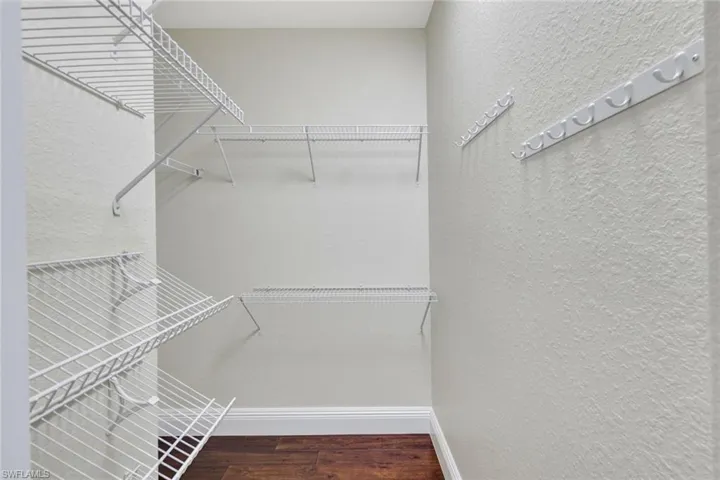 Walk in closet featuring dark wood finished floors