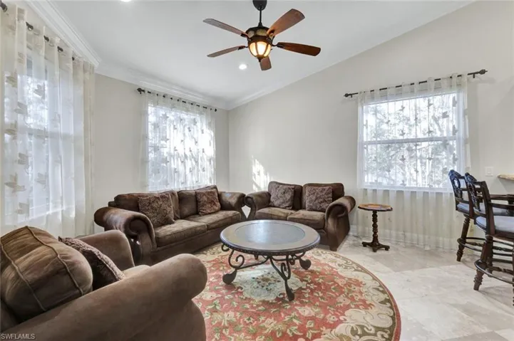 Living area featuring crown molding, healthy amount of natural light, recessed lighting, and ceiling fan