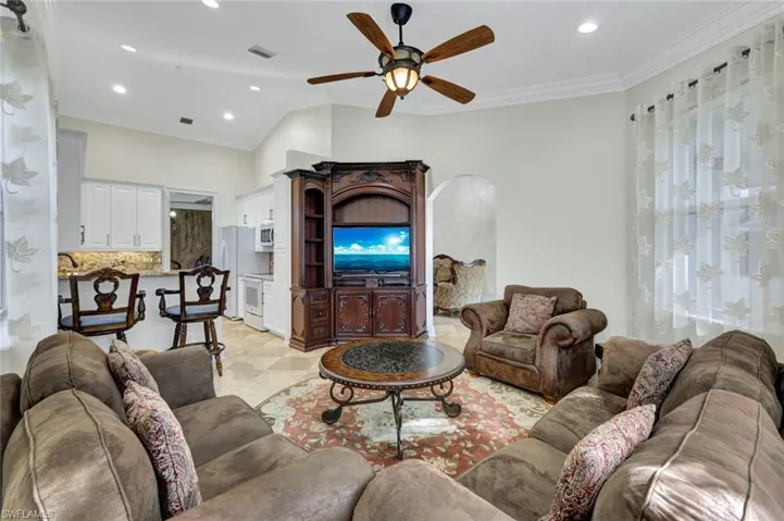 Living area featuring ornamental molding, ceiling fan, recessed lighting, and arched walkways