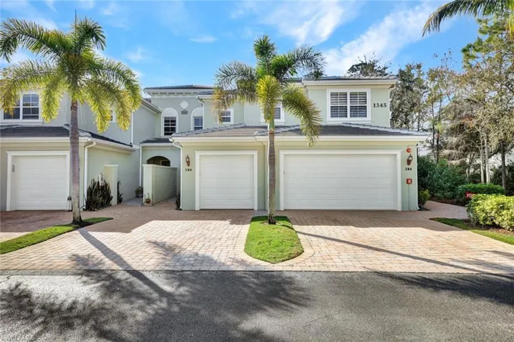 View of front of home featuring decorative driveway, stucco siding, and an attached garage