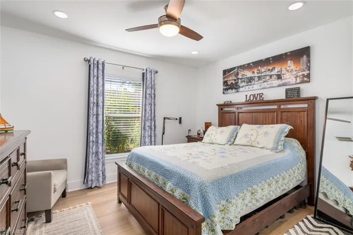Bedroom with light wood-style floors, a ceiling fan, and recessed lighting