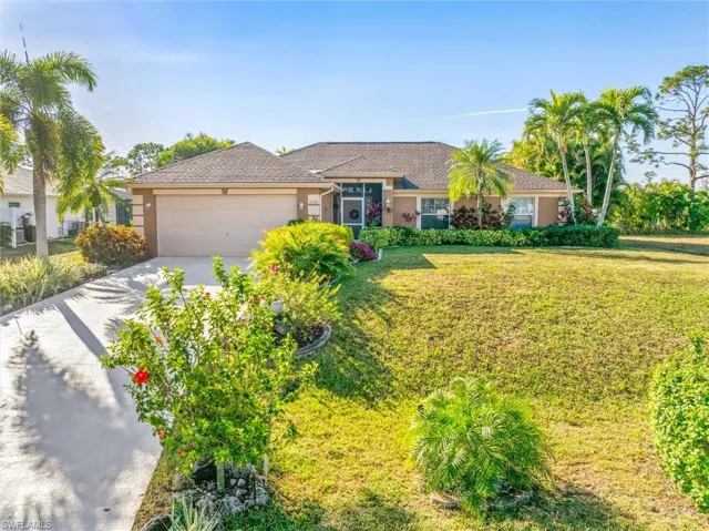 Ranch-style house featuring driveway, stucco siding, a front yard, and a garage