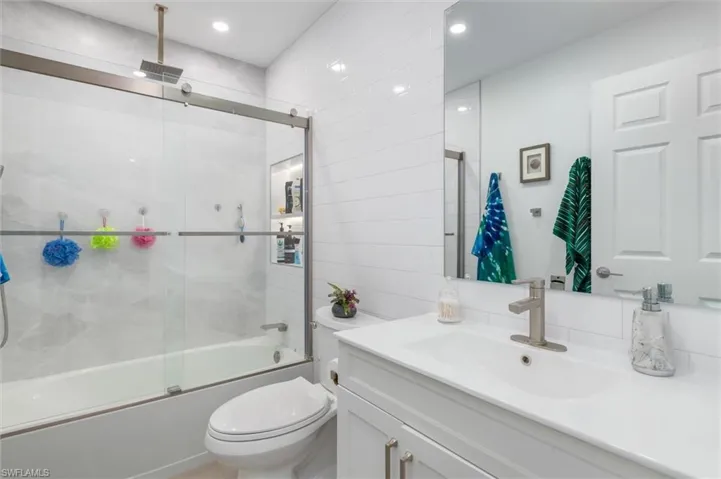 Bathroom with vanity and a combined bath / shower with rainfall shower