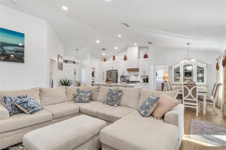 Living area featuring a chandelier, recessed lighting, high vaulted ceiling, and light wood-style floors