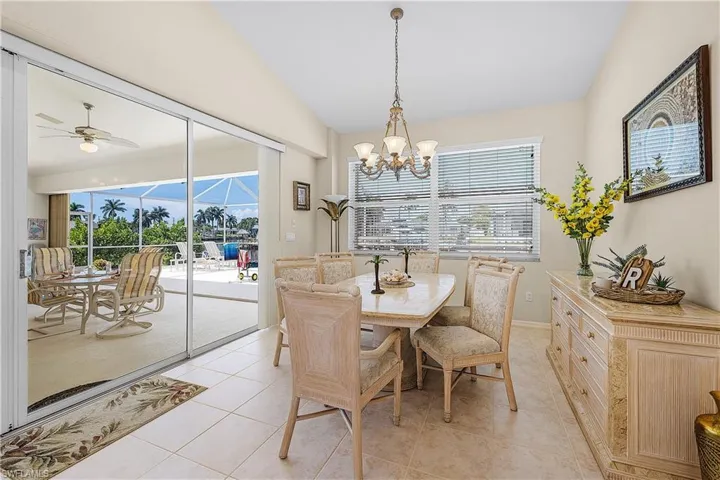 Dining room with large sliders to screened in lanai. Clean tile flooring.