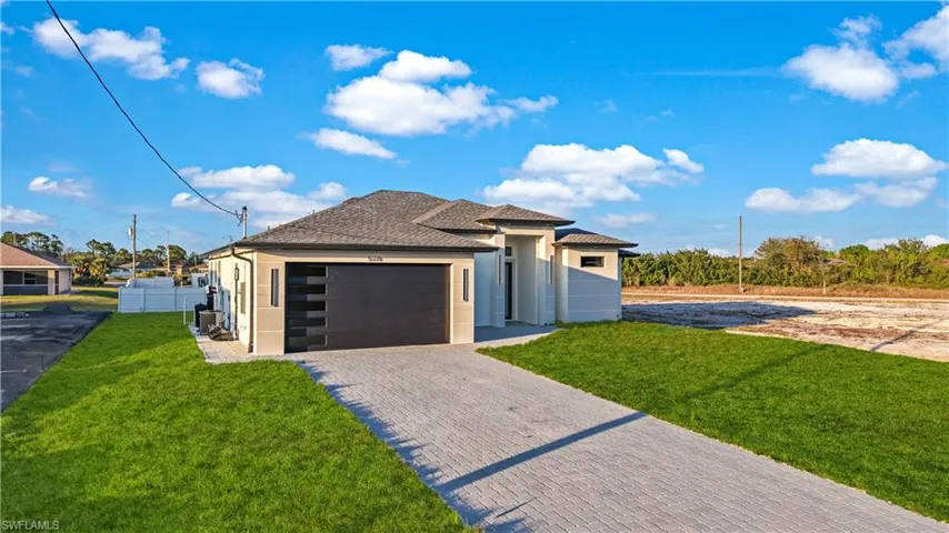 View of front of house with a garage and a front yard