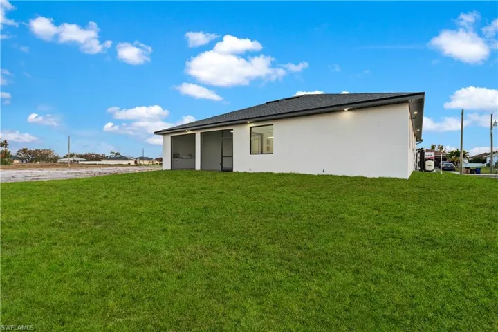 Rear view of property with a yard