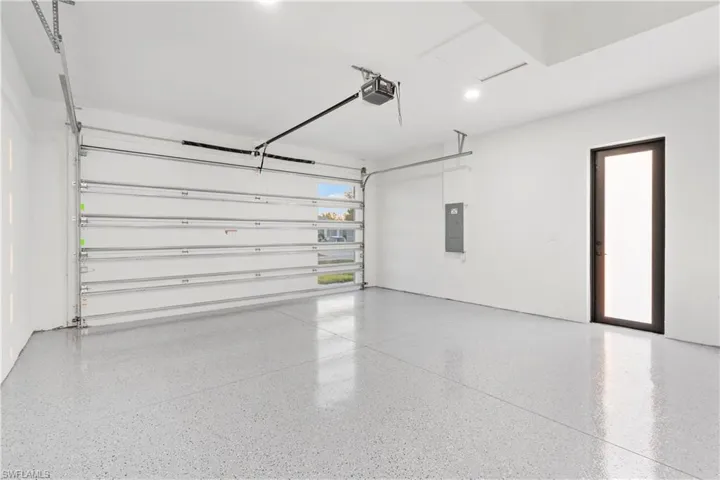 Garage featuring a garage door opener and electric panel