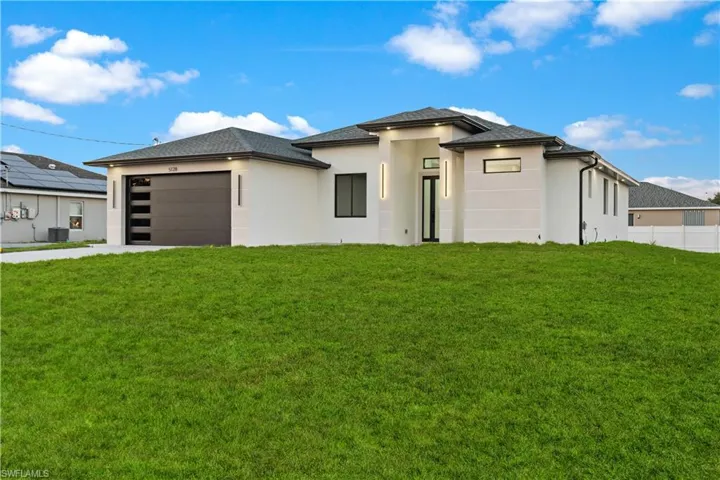 Contemporary style home with insulated impact garage door, lusciously green front lawn