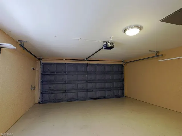 Garage featuring a textured wall and a garage door opener