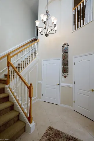 Entryway with a chandelier, light tile patterned floors, and a high ceiling