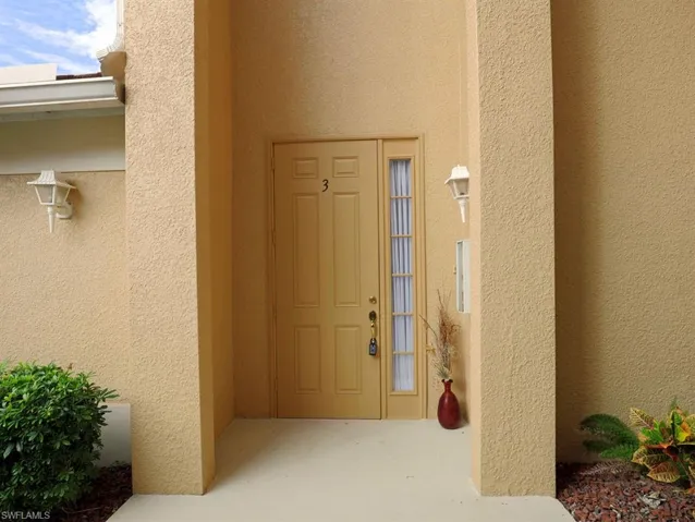 Property entrance featuring stucco siding
