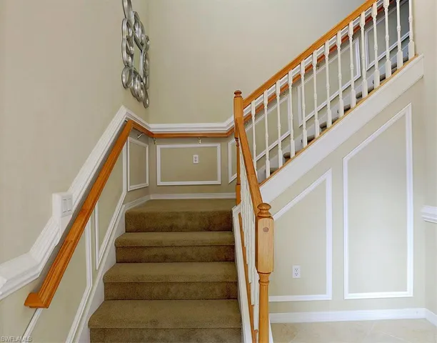 Staircase featuring a decorative wall
