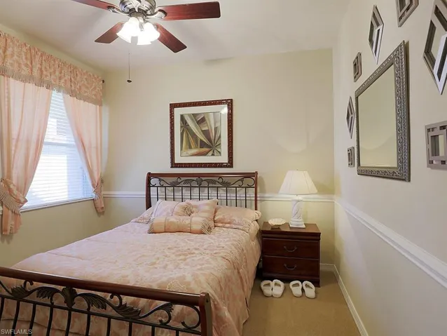 Carpeted bedroom with baseboards and a ceiling fan