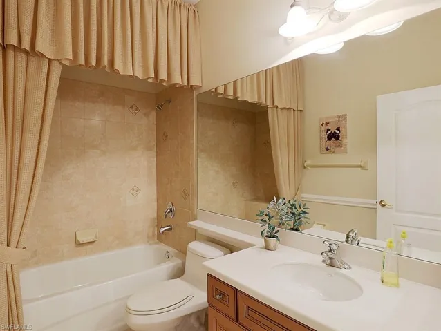 Bathroom with vanity and shower / bathtub combination with curtain