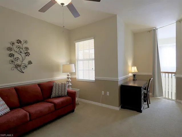 Living area featuring light carpet and ceiling fan