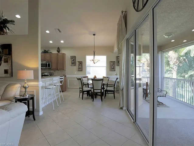 Dining room with wainscoting, a decorative wall, light tile patterned floors, and recessed lighting