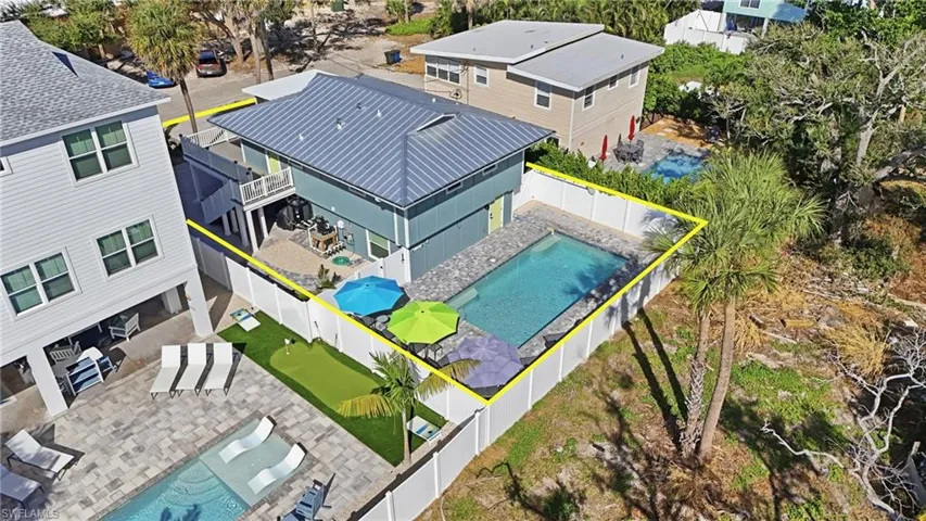 Aerial view of rear of house and pool featuring a pool area and property boundaries highlighted- Virtually Edited Image