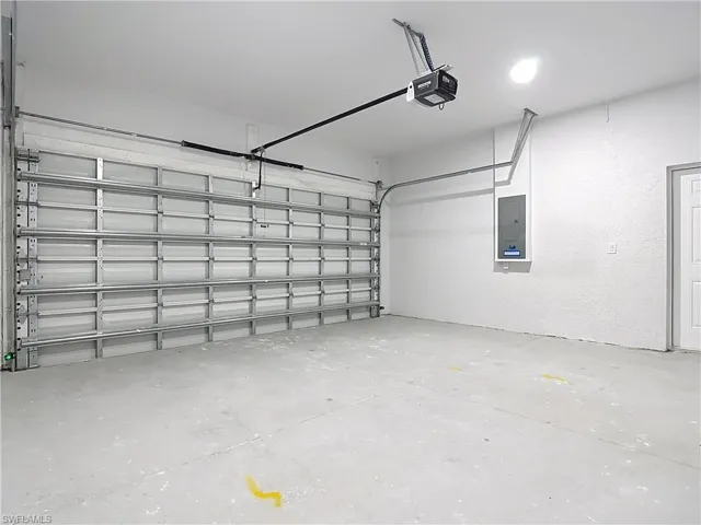 Garage with electric panel and a garage door opener