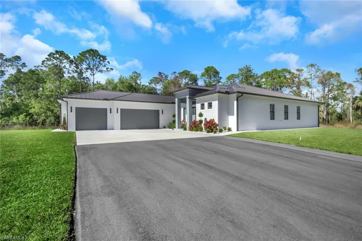 Contemporary home with a front yard, asphalt driveway, and a garage