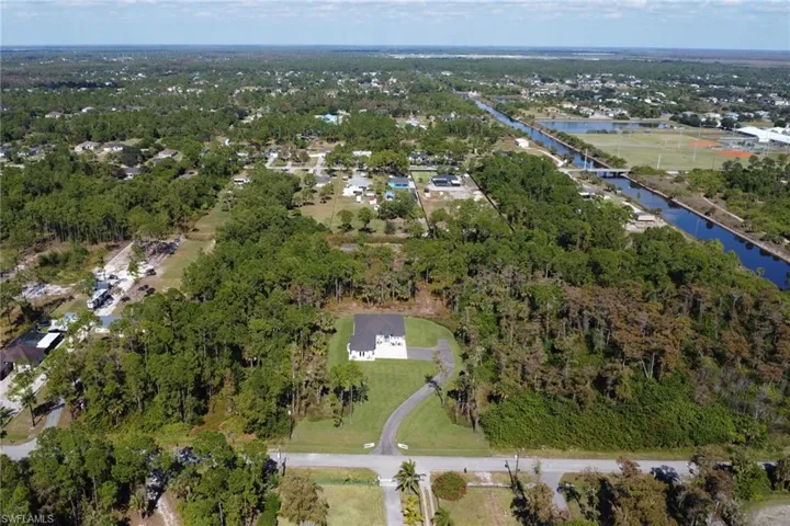 Aerial view of property's location with a large body of water and a tree filled landscape