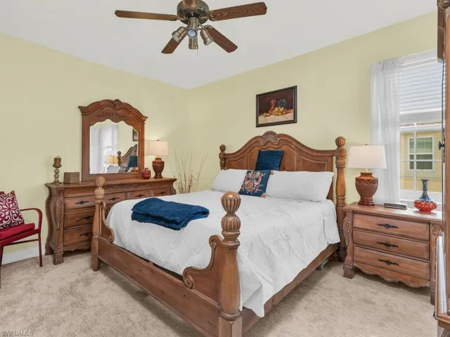 Bedroom with ceiling fan and light colored carpet