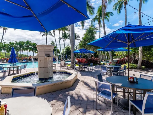 View of patio with pool water feature and a community pool