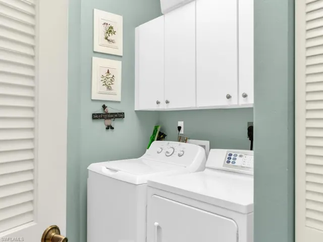 Washroom with washing machine and dryer and cabinets