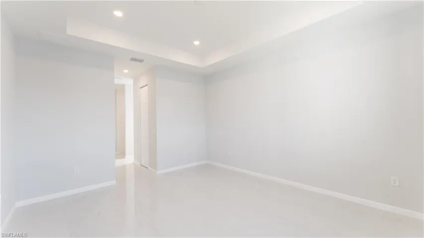 Primary Unfurnished room featuring a raised ceiling