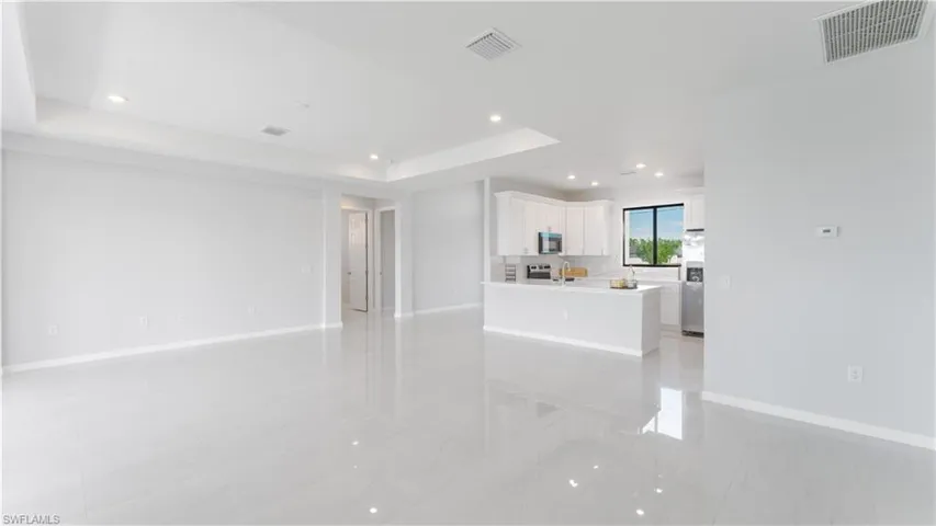 Unfurnished living room featuring a tray ceiling