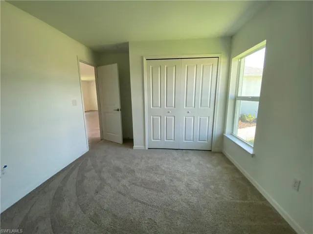 Unfurnished bedroom with a closet and carpet floors