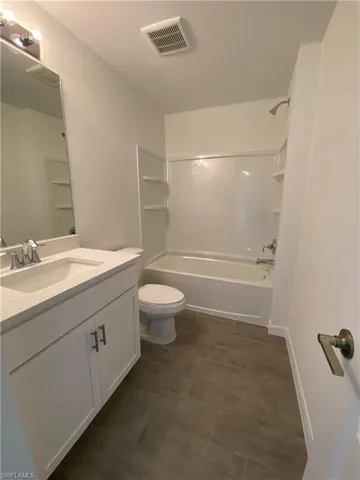 Full bathroom with washtub / shower combination, vanity, and toilet