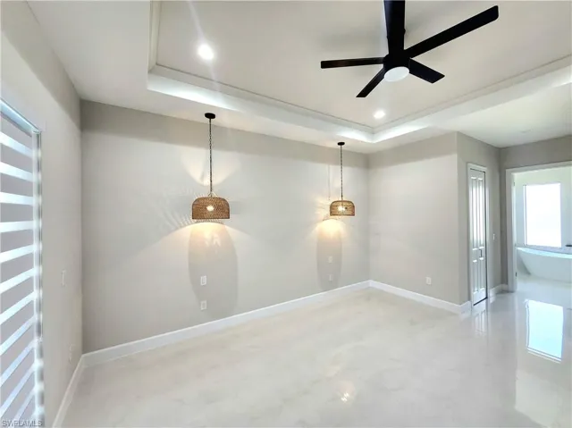 Spare room featuring a raised ceiling, a ceiling fan, and recessed lighting