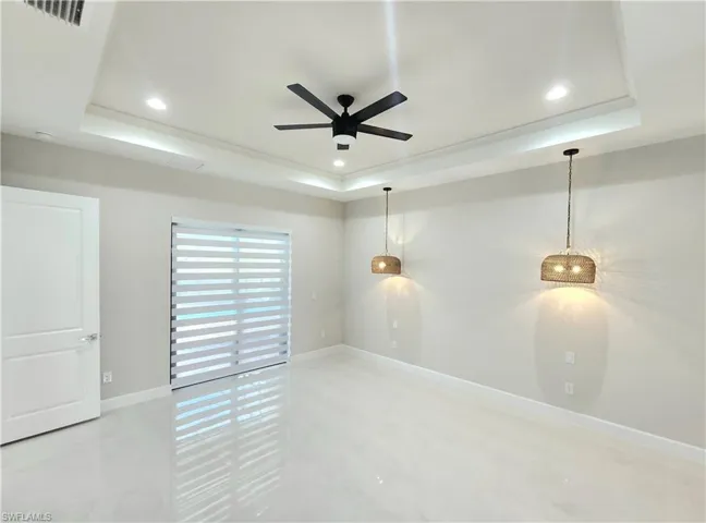 Unfurnished room featuring a tray ceiling, a ceiling fan, and recessed lighting