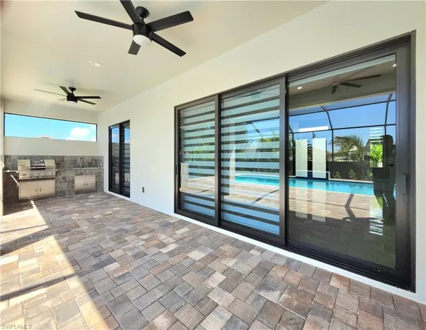 View of patio featuring area for grilling and a ceiling fan