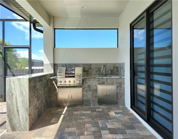 View of patio / terrace featuring exterior kitchen and a sunroom