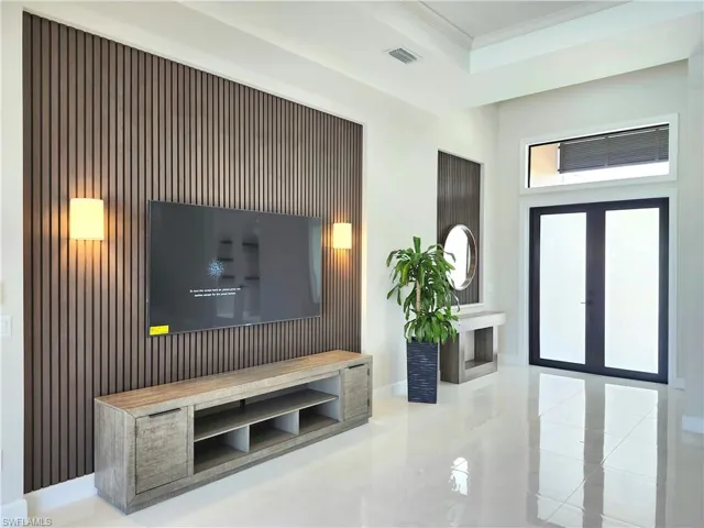Living room with ornamental molding and light tile patterned floors