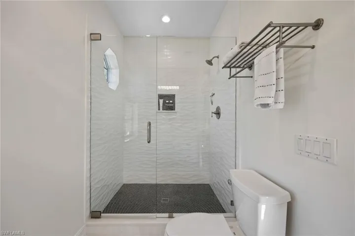 Bathroom featuring toilet, a stall shower, and recessed lighting