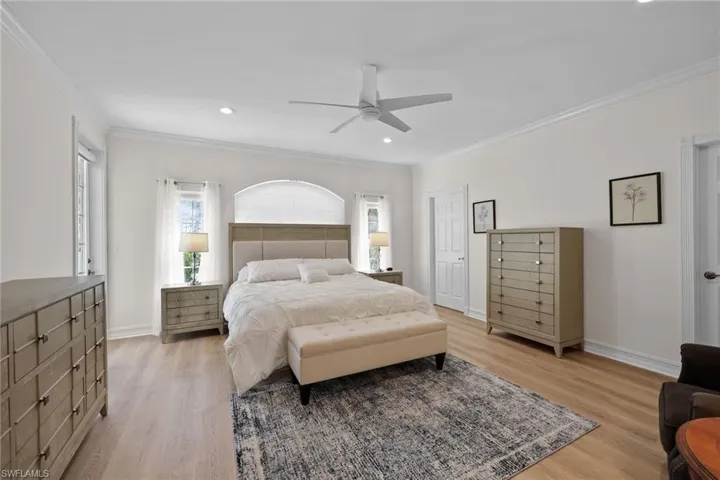 Bedroom with light wood-type flooring, ornamental molding, recessed lighting, baseboards, and a ceiling fan