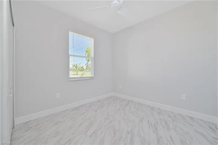 Tiled empty room with ceiling fan