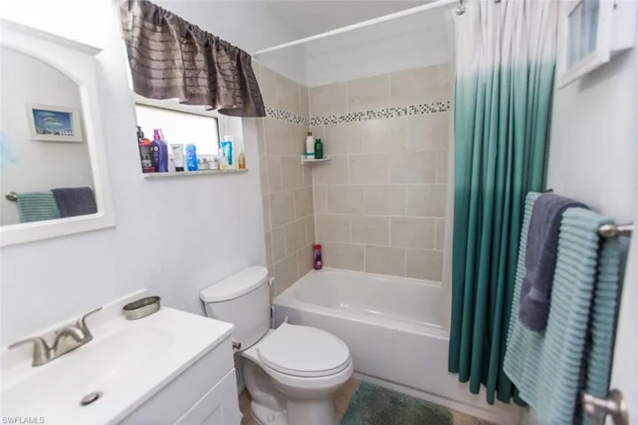 Full bath featuring vanity and shower / bathtub combination with curtain