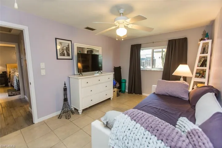 Guest Bedroom with light tile patterned floors and a ceiling fan