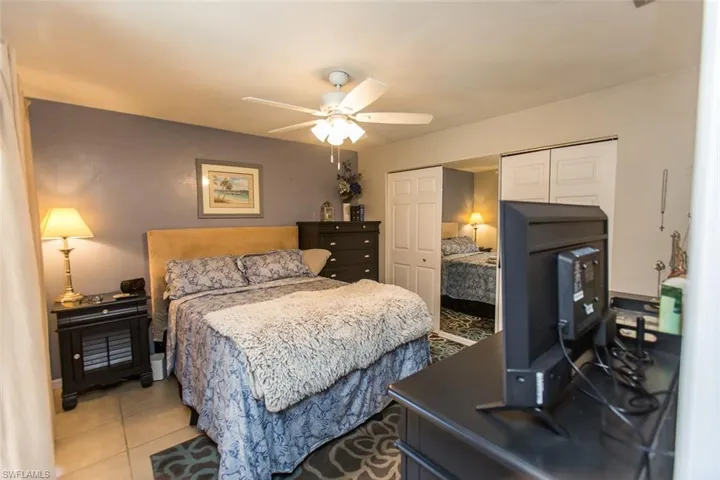 Tiled bedroom with two closets and ceiling fan