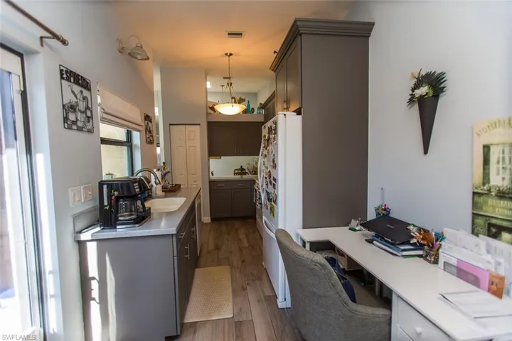 Kitchen featuring light countertops, desk or breakfast nook decorative light fixtures, dark wood-type flooring, and a desk