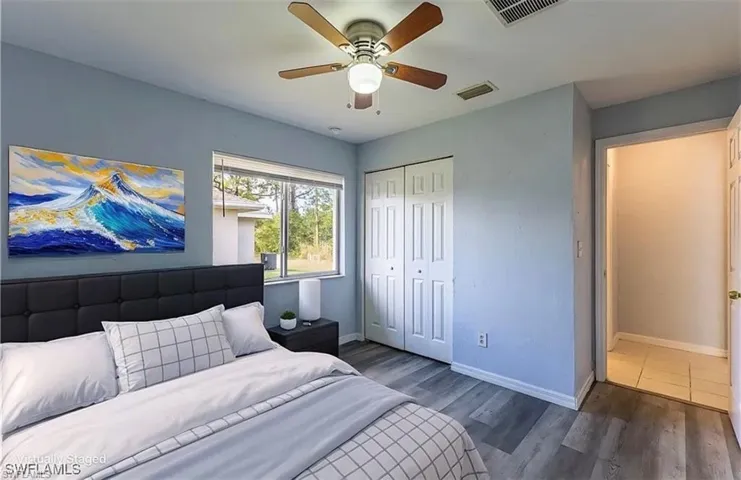 Bedroom featuring wood finished floors, a closet, and ceiling fan