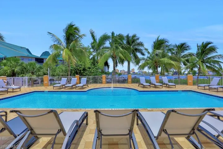 Community pool featuring fence and a patio area