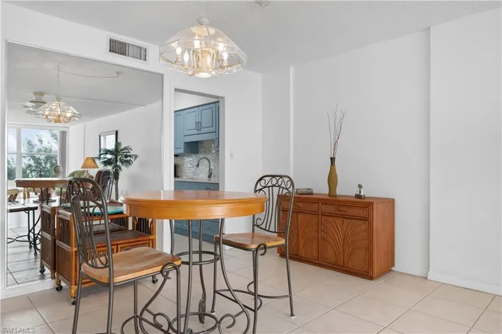 Dining area featuring a chandelier, light tile patterned floors, and a textured ceiling