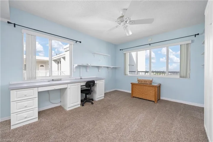 Office featuring healthy amount of natural light, light colored carpet, a textured ceiling, and ceiling fan