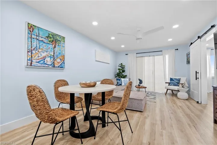 Dining area featuring recessed lighting, a barn door, light wood-style floors, and baseboards