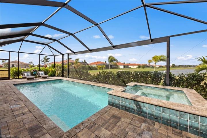 New extended screened cage with PICTURE FRAME screen, long lake and golf course views, HEATED POOL and SPA with pool lights, deck jets, and waterfall feature (March 2023). New landscaping and stone edging (April 2023).